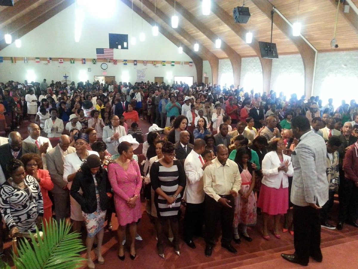 A full sanctuary at Dabar Bethlehem Cathedral, the congregation standing together in worship.