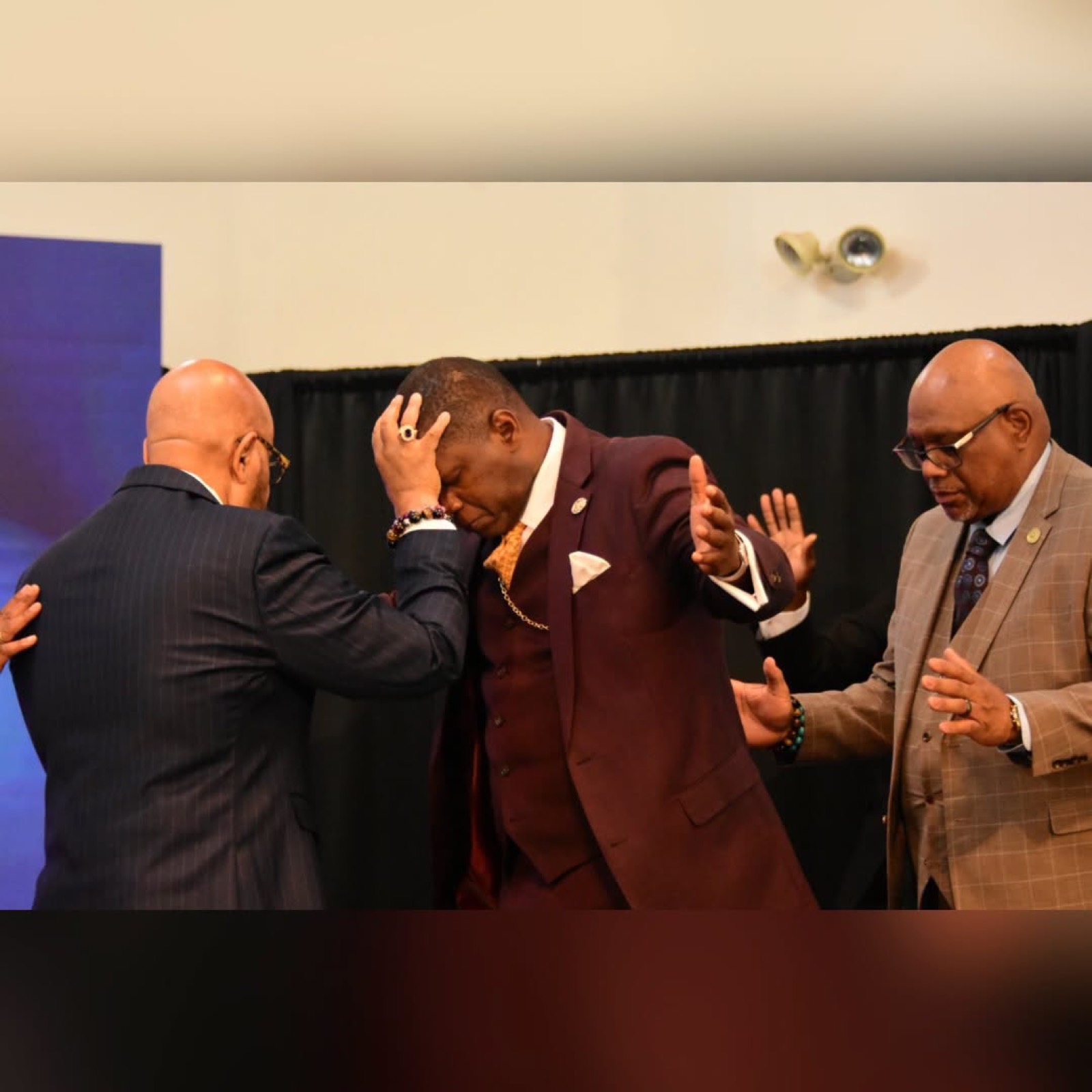 Ministers lay hands and pray over Bishop H. Curtis Douglas.